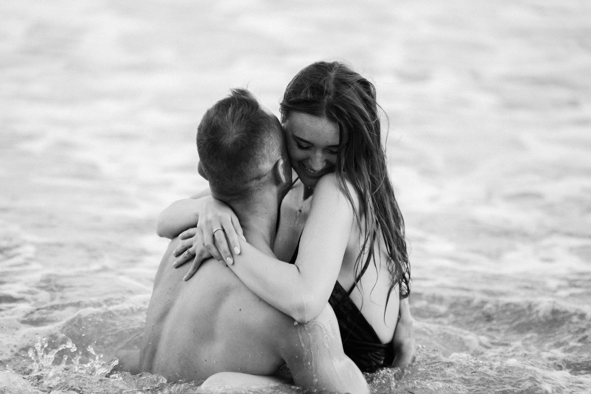 Couple enlacé au bord de la mer, en noir et blanc