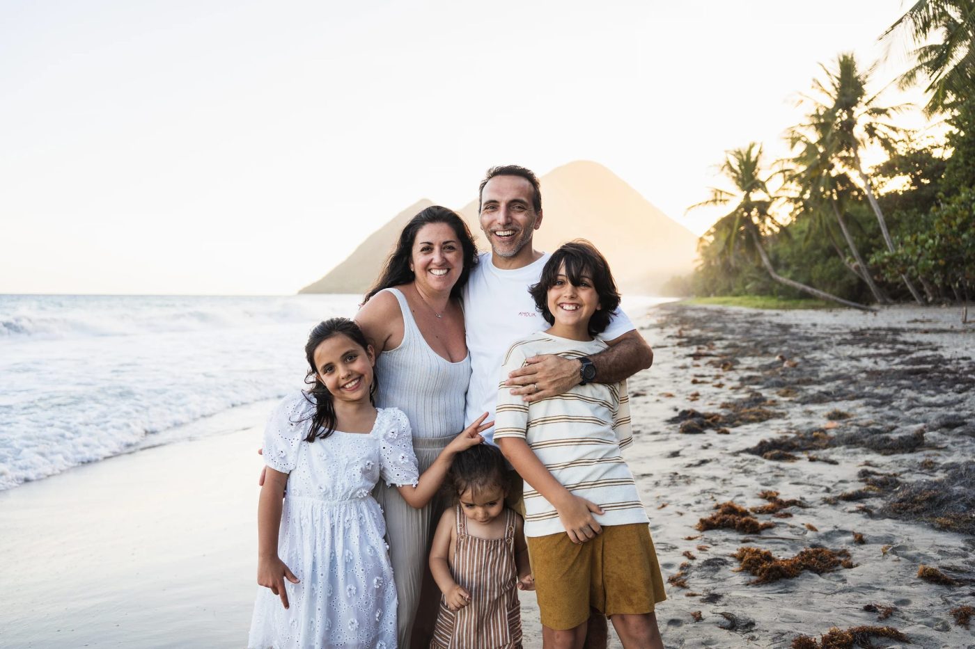 Famille photographiée au coucher du soleil sur la plage