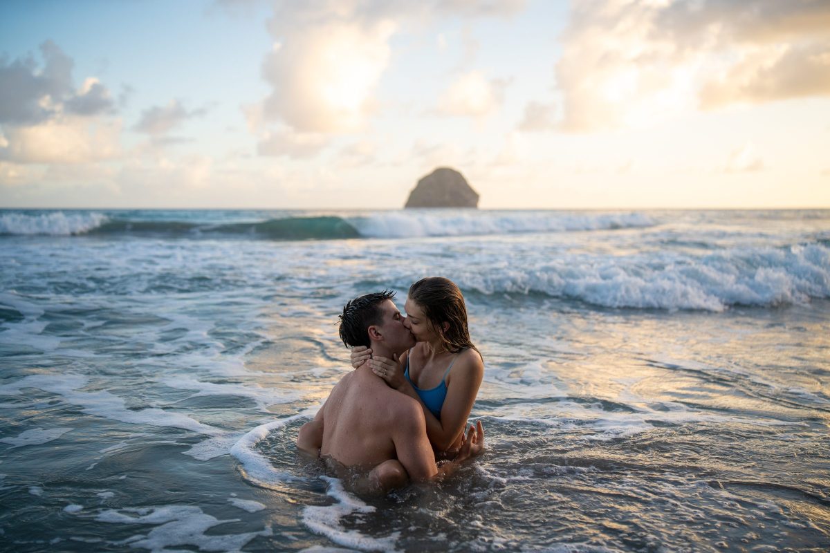 Couple enlacé dans les vagues devant le rocher du Diamant, en Martinique