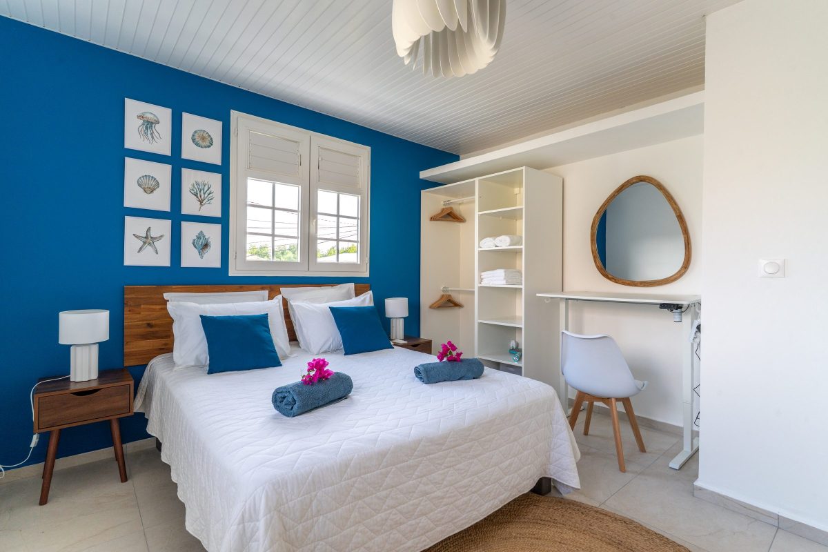 Chambre aux murs bleus d'une location en Martinique